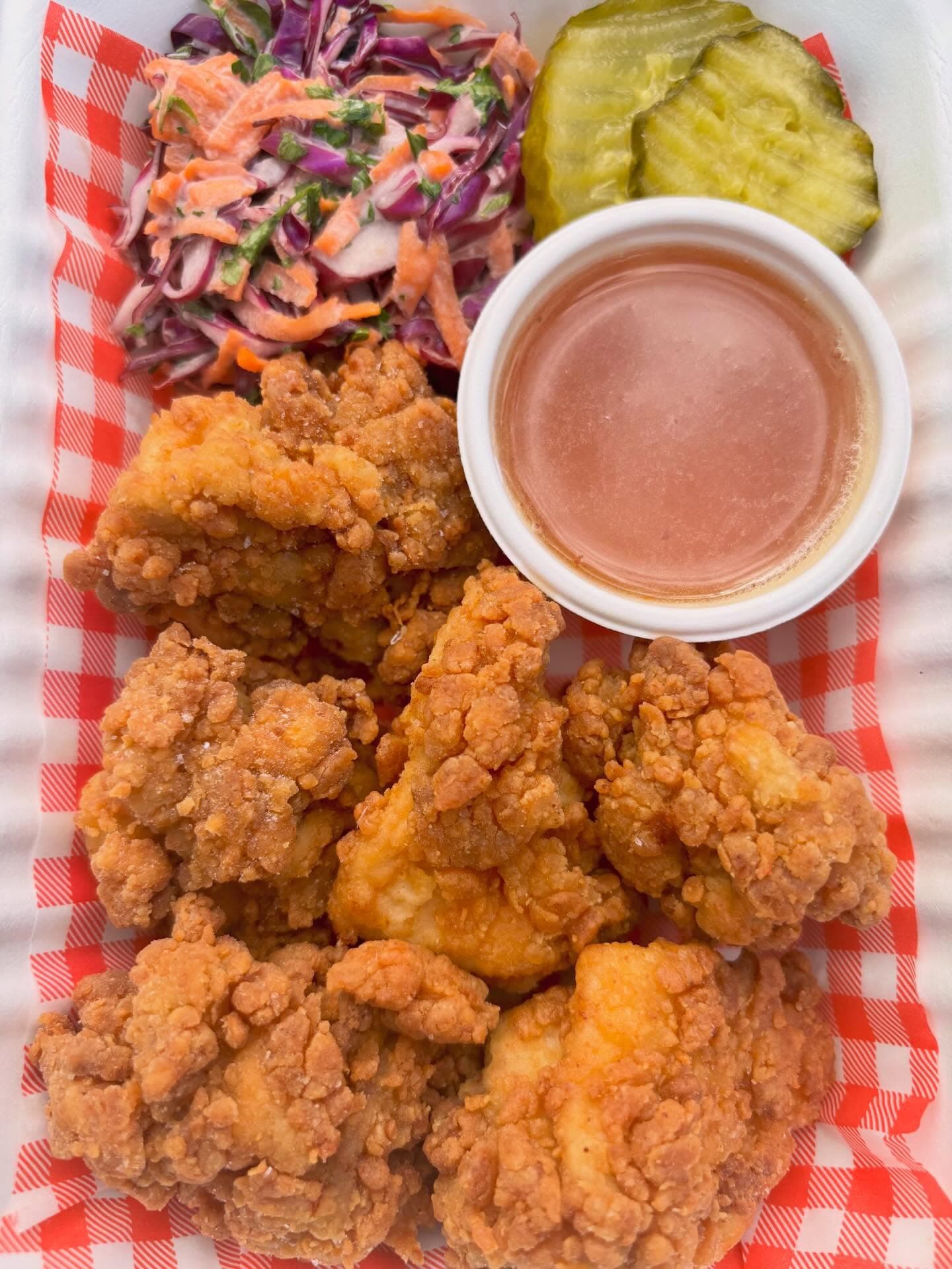 Burchie's fried chicken bites served with slaw, pickles, and sauce